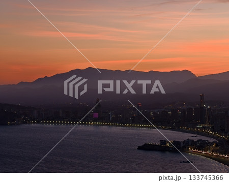 foggy coastal cityscape at dusk, twilight fog surrounds tranquil seaside town and mountains 133745366