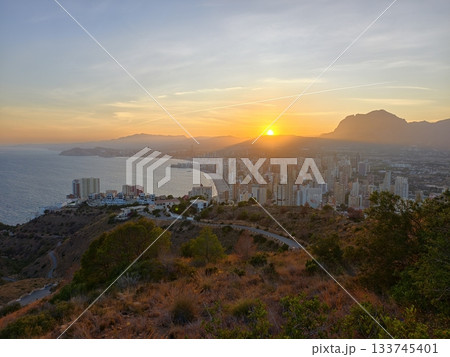 hiking at sunset overlooking coast, coastal city sunset viewed from hillside with rugged paths hiking at sunset overlooking coast, coastal city sunset viewed from hillside with rugged paths 133745401