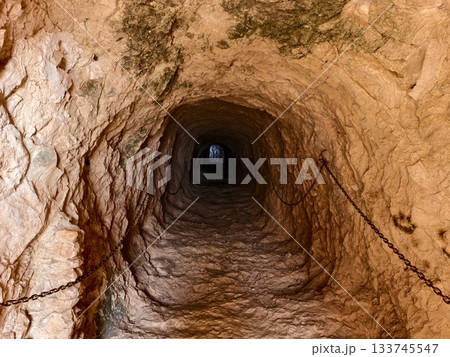 ancient tunnel with layered stones, excavation site revealing ancient tunnel with sediment and stone 133745547