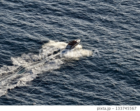 highenergy coastal chase with speedboat, dynamic speedboat racing across open water under bright sky highenergy coastal chase with speedboat, dynamic speedboat racing across open water under bright sky 133745567