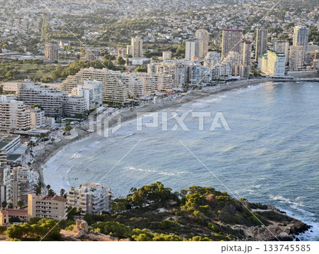 vivid beachside neighborhood scene, sunlit shoreline bustling with energetic local activities 133745585