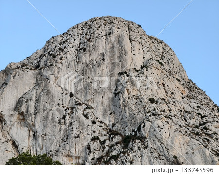 mountain face featuring cracks and shadows, rugged rock surface with visible fissures and shadows mountain face featuring cracks and shadows, rugged rock surface with visible fissures and shadows 133745596