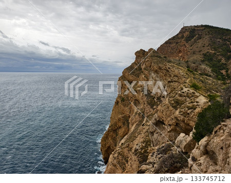 rugged cliffs meet turquoise waters, vast rocky cliff over vibrant turquoise ocean with erosion 133745712