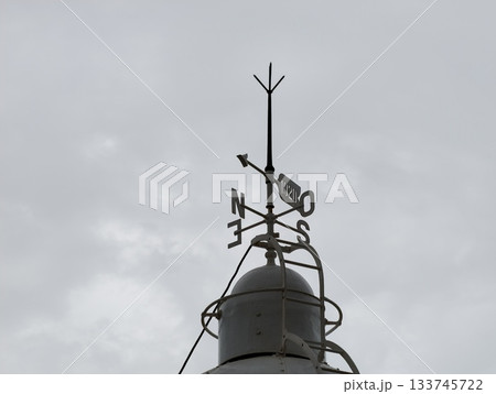 atmospheric old weather vane with rusted finish, vintage rusty vane perched overhead creating 133745722