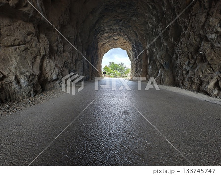 scenic tunnel glimpse, paved tunnel with reflective asphalt directs gaze toward distant horizon scenic tunnel glimpse, paved tunnel with reflective asphalt directs gaze toward distant horizon 133745747