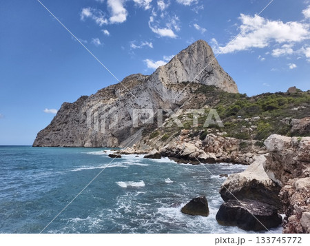 jagged cliffs adjacent to tranquil azure seas, rugged cliffs overlooking calm blue waters with boat jagged cliffs adjacent to tranquil azure seas, rugged cliffs overlooking calm blue waters with boat 133745772