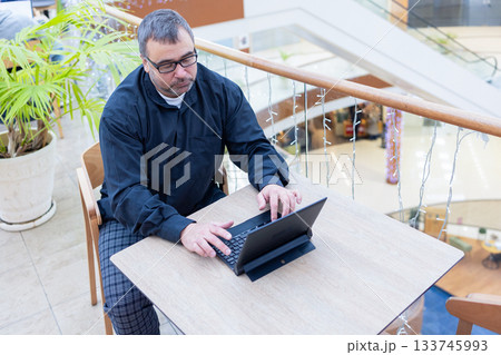 Businessman in suit and sunglasses working on laptop in modern office. High quality photo Businessman in suit and sunglasses working on laptop in modern office. High quality photo 133745993