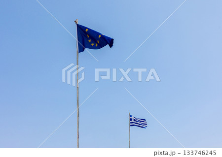 European Union EU and Greece flags is flying in air on blue sky background. Banner, place for text. High quality photo European Union EU and Greece flags is flying in air on blue sky background. Banner, place for text. High quality photo 133746245