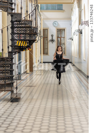 Beautiful girl in black dress running in hall checkered floor. High quality photo 133746248