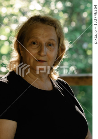 Portrait of elderly woman close-up on natural background. Profile of man with sunset sunlight on his face. High quality photo Portrait of elderly woman close-up on natural background. Profile of man with sunset sunlight on his face. High quality photo 133746264