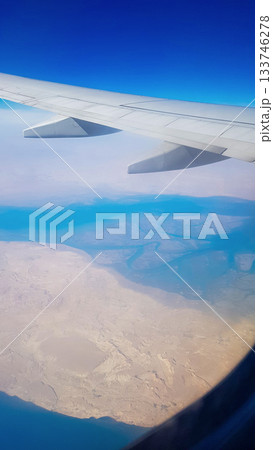 View from the window of plane on blue sky and earth with landscape of desert, sea and canals in Emirates. High quality photo 133746278