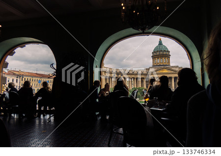 View of Kazan Cathedral from Singer Cafe through window. Silhouettes of people sitting at tables in old Singer House in Saint-Petersburg, Russia. High quality photo View of Kazan Cathedral from Singer Cafe through window. Silhouettes of people sitting at tables in old Singer House in Saint-Petersburg, Russia. High quality photo 133746334