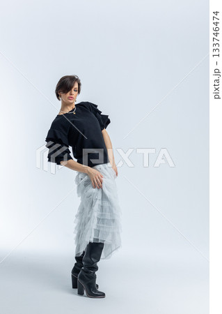 Beautiful model in black jumper, light grey skirt on white background. High fashion. Vertical photo. High quality photo Beautiful model in black jumper, light grey skirt on white background. High fashion. Vertical photo. High quality photo 133746474