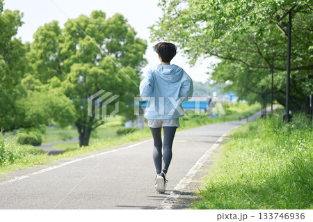 屋外でランニングする40代女性 後ろ姿 屋外でランニングする40代女性 後ろ姿 133746936