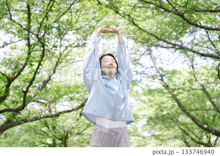 屋外で準備運動をする40代女性 133746940