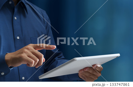 タブレットPCを使う男性。タブレットの画面をタップする手のクローズアップ。スマートモバイルデバイスと 133747861