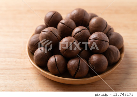 Macadamia nuts in a bowl on wooden background Macadamia nuts in a bowl on wooden background 133748173