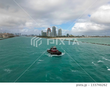 Tugboat leading to port of Miami. Tugboat sailing in sea. Boat transport. Sea vessel transportation. Miami port Tugboat leading to port of Miami. Tugboat sailing in sea. Boat transport. Sea vessel transportation. Miami port 133748262