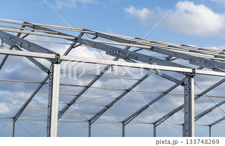 Architectural detail. Installation of metal structure outside. Metal construction. Structural design engineering. Structure engineering at building site. Framework construction architecture Architectural detail. Installation of metal structure outside. Metal construction. Structural design engineering. Structure engineering at building site. Framework construction architecture 133748269