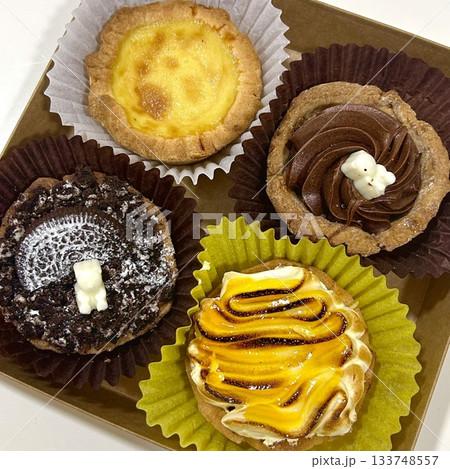 Buttery and flaky egg tart filled with smooth custard and topped with fresh fruits. A perfect blend of creamy sweetness and fruity freshness for a delightful and elegant dessert. 133748557