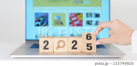 2025 end year to Happy New Year 2026 block magnifying glass icon against laptop background. Hiring, recruitment, job, jobless SEO, Search Engine Optimization and New Year concepts 133749920