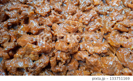 Macro Shot of Beef Chunks Coated in Thick, Red Rendang Sauce during Cooking Macro Shot of Beef Chunks Coated in Thick, Red Rendang Sauce during Cooking 133751169