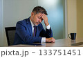 ストレス葛藤でオフィスの机で頭を抱える日本人ビジネスマン 133751451