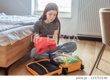 Woman packing suitcase with clothes for vacation travel Woman packing suitcase with clothes for vacation travel 133753146