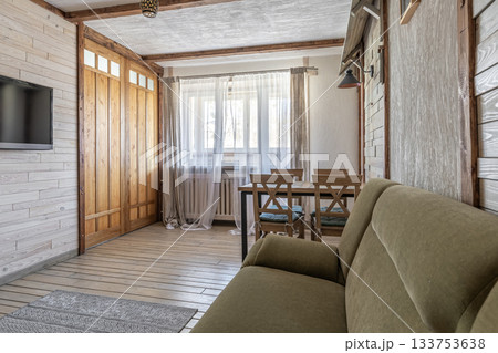 Cozy Living Room with Green Sofa and Wooden Dining Area Cozy Living Room with Green Sofa and Wooden Dining Area 133753638