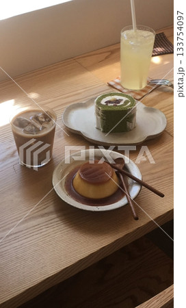 A delightful assortment of desserts displayed in a cozy cafe setting, featuring cakes, pastries, and sweet treats on elegant plates, creating a warm and inviting atmosphere. A delightful assortment of desserts displayed in a cozy cafe setting, featuring cakes, pastries, and sweet treats on elegant plates, creating a warm and inviting atmosphere. 133754097