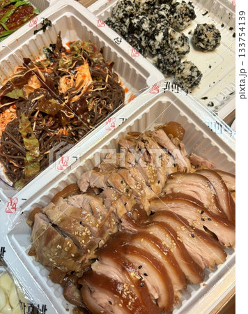 Jokbal, a Korean dish of braised pork hock, slow-cooked in a rich, savory sauce with soy, garlic, and spices. Tender and flavorful, it’s often served with lettuce wraps, garlic, and ssamjang 133754139