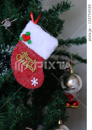 A red Christmas stocking with the words Merry Christmas hanging on the Christmas tree. A red Christmas stocking with the words Merry Christmas hanging on the Christmas tree. 133754589