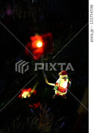 Small Santa Claus string lights plugged in and wrapped around the Christmas tree. Small Santa Claus string lights plugged in and wrapped around the Christmas tree. 133754596