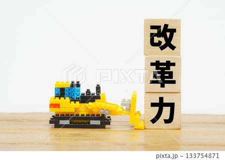 改革力を象徴するブルドーザーと文字ブロックの構図 改革力を象徴するブルドーザーと文字ブロックの構図 133754871