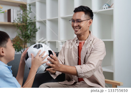 Family Life: Father and son playing with a soccer ball at home Family Life: Father and son playing with a soccer ball at home 133755650