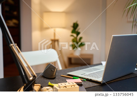 Home office workspace with laptop and vertical mouse on desk 133756045
