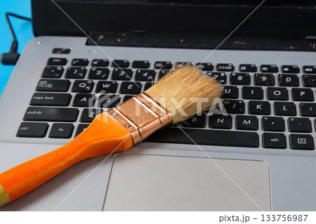 A carefully cleaning a dusty keyboard with a small brush. A carefully cleaning a dusty keyboard with a small brush. 133756987