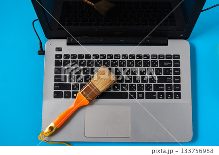 A carefully cleaning a dusty keyboard with a small brush. A carefully cleaning a dusty keyboard with a small brush. 133756988