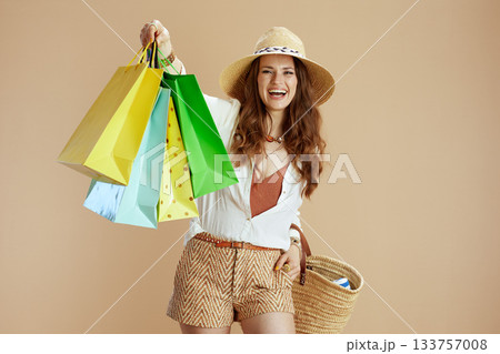happy woman in blouse and shorts against beige 133757008