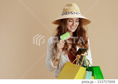 smiling elegant housewife in blouse and shorts against beige 133757009