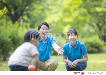 子供と遊ぶ青いポロシャツの男女スタッフ 133757424
