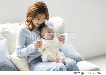 赤ちゃんを抱いている母親　 133757826