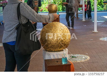 Devotee gilding temple sphere 133758237