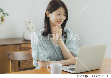 部屋でパソコンを見る女性 部屋でパソコンを見る女性 133758301