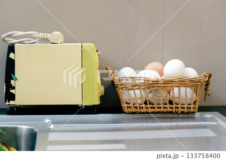 Eggs in a basket and toaster on the kitchen table 133758400