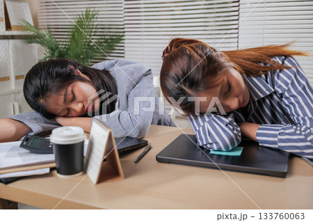 Young business women colleagues work online from home office, people on team exhausted, sleeping at desks after demanding work, learn session causing fatigue. 133760063