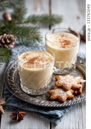 Eggnog Christmas milk cocktail with cinnamon, served in two glasses on vintage tray with shortbread star shape sugar cookies Eggnog Christmas milk cocktail with cinnamon, served in two glasses on vintage tray with shortbread star shape sugar cookies 133761049