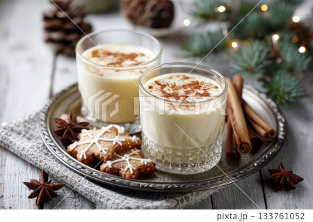 Eggnog Christmas milk cocktail with cinnamon, served in two glasses on vintage tray with shortbread star shape sugar cookies 133761052