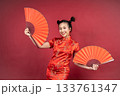 Happy Chinese girl in Cheongsam holding traditional paper fans in studio Happy Chinese girl in Cheongsam holding traditional paper fans in studio 133761347