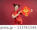 Lucky Chinese girl in traditional dress displaying calligraphy for prosperity. Lucky Chinese girl in traditional dress displaying calligraphy for prosperity. 133761348